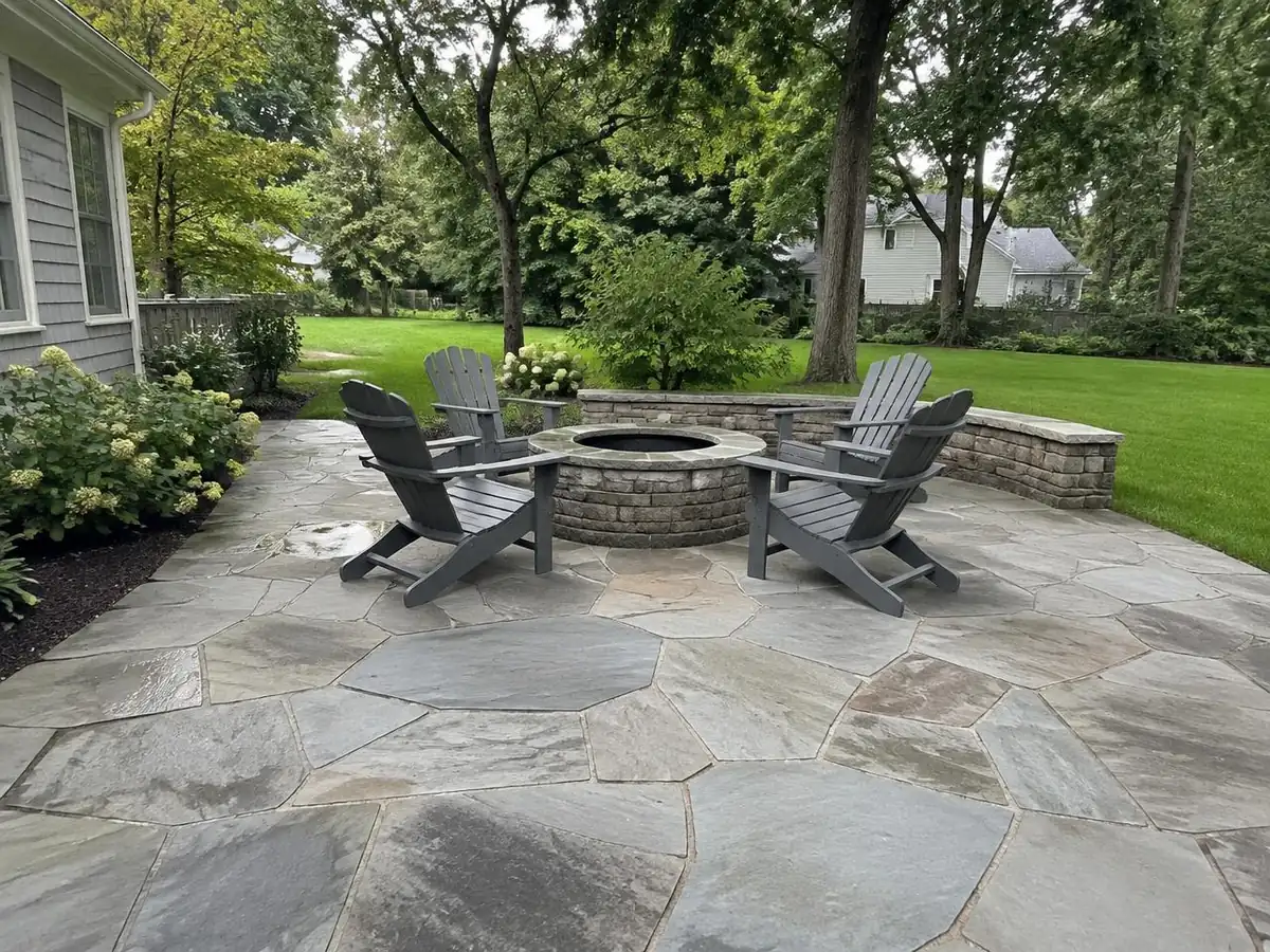 Bluestone patio with fieldstone edging behind a New England colonial home in Peabody, MA