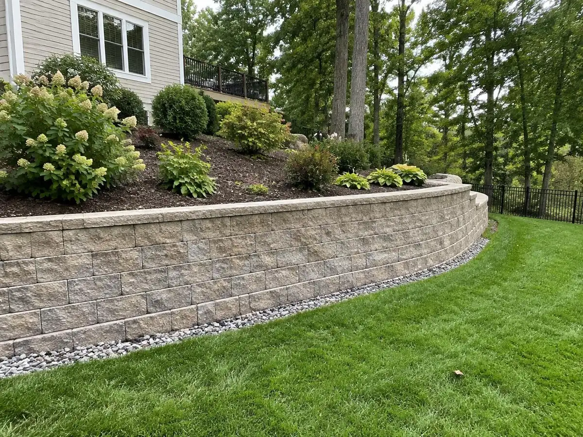 Segmental block retaining wall with cap stones terracing a sloped residential yard on the North Shore